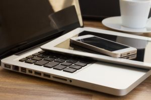 laptop tablet and smart phone laying on top of each other