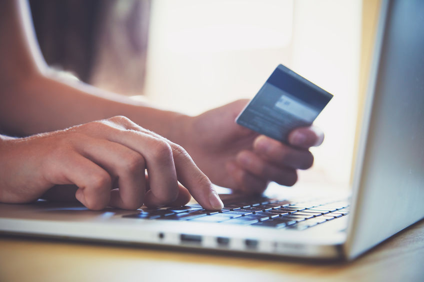 Person entering a credit card on a laptop to shop online